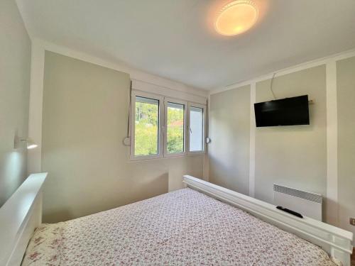 a bedroom with a bed and a flat screen tv at Melanie- City Centre Apartment in Herceg-Novi