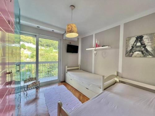 um quarto com 2 camas e uma janela em Melanie- City Centre Apartment em Herceg Novi