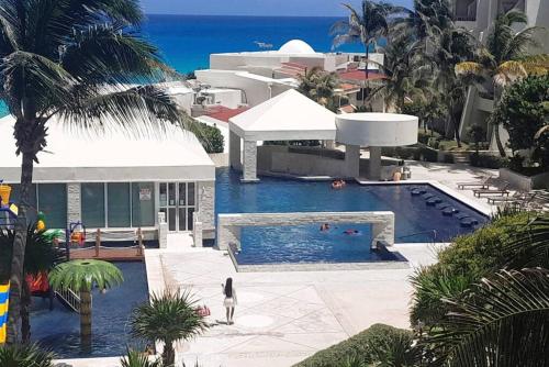 a building with a swimming pool next to the ocean at Seaside Escape Studio in Cancun Beach in Cancún