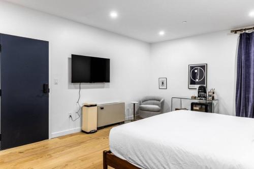 a bedroom with a bed and a flat screen tv at King Bed , DTWN, 50 in Roku TV , Fiber Internet, Room # 203 in Bangor