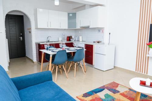 cocina con sofá azul y mesa con sillas en WhiteHome Apartment en Xanthi