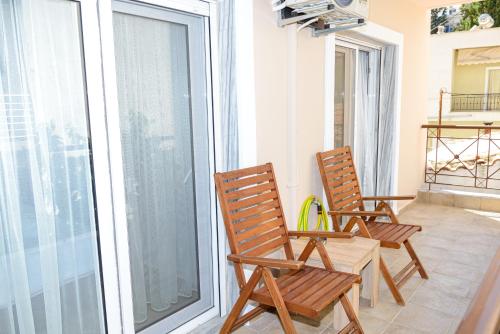 2 sillas de madera sentadas en un balcón en WhiteHome Apartment en Xanthi