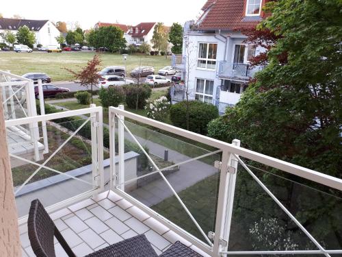 a balcony with a white railing and chairs on it at Hotel Markkleeberger Hof in Markkleeberg