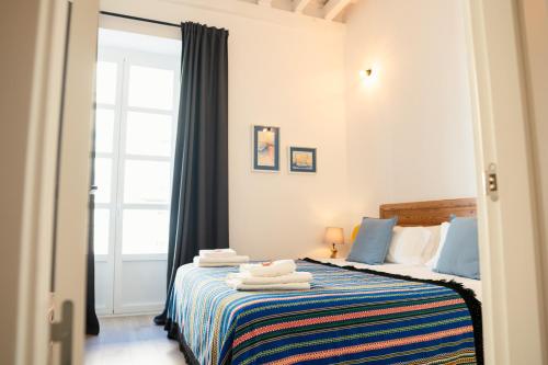 a bedroom with a bed with towels on it at Casa Miguel - Apartamento 3 in Sanlúcar de Barrameda