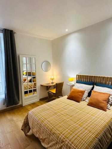 une chambre avec un grand lit et un bureau dans l'établissement Le clair de lune - hyper centre, à Charleville-Mézières