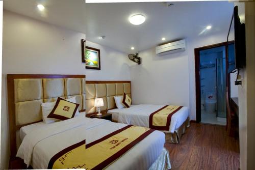a hotel room with two beds and a window at Van Mieu 2 Hotel in Hanoi