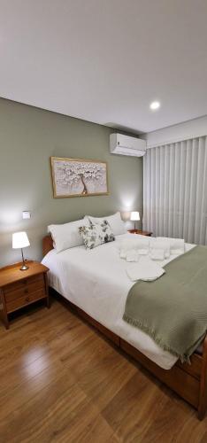 a bedroom with a large white bed and two lamps at Casa Filó in Peso da Régua