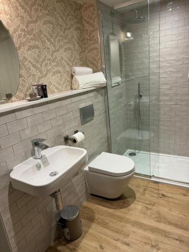 a bathroom with a toilet and a sink and a shower at The Falcon Inn in Scarborough