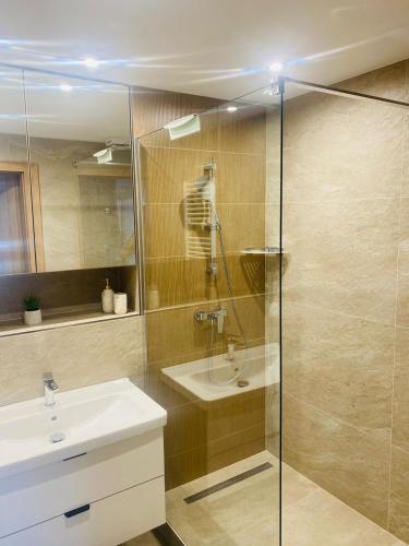 een badkamer met een glazen douche en een wastafel bij Modern appartment in Banská Bystrica