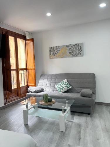 a living room with a couch and a glass table at Rosal Central Studios in Oviedo