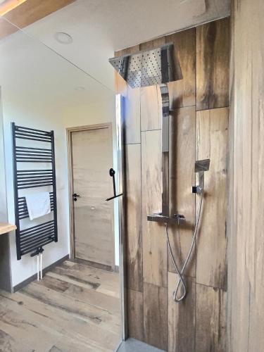 une douche dans une salle de bain avec un mur en bois dans l'établissement Maison familiale des Privilèges, à Gérardmer