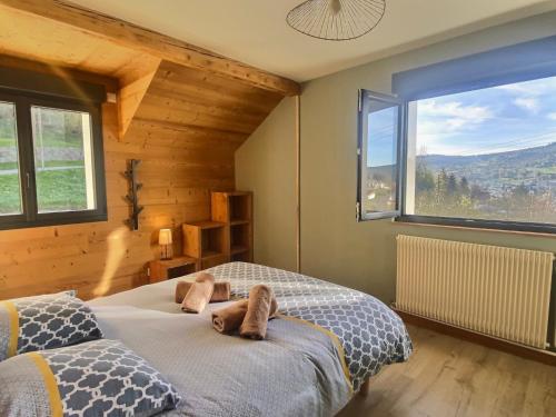 a bedroom with two beds and a large window at Maison familiale des Privilèges in Gérardmer