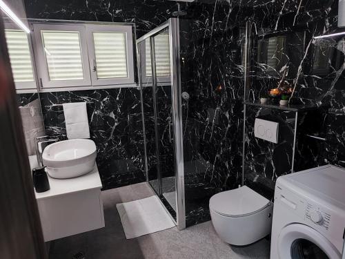 een badkamer met een wastafel en een douche bij Apartment Ruža in Trogir