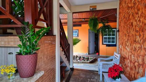 two images of a house with a porch with a plant at Pousada Enseada da Vila in Cabo Frio