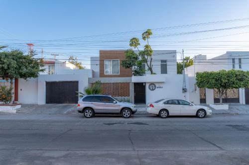 two cars parked in a parking lot in front of a house at CASa SENECA in La Paz