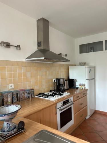 une cuisine avec une cuisinière et un réfrigérateur dans l'établissement T3 Ajaccio rte des Sanguinaires, à Ajaccio