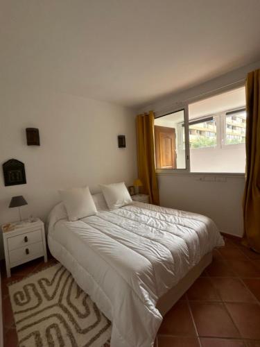 une chambre avec un grand lit et une fenêtre dans l'établissement T3 Ajaccio rte des Sanguinaires, à Ajaccio