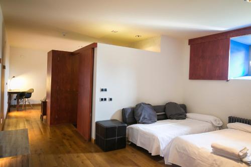 a living room with two beds and a table at Hotel Boutique El Convento de Mave in Santa María de Mave