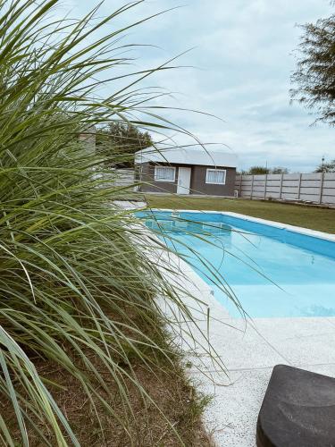 聖地亞哥－德爾埃斯特羅的住宿－Finca Amankay con alojamiento para 5 personas，大型蓝色游泳池,长着高大的草