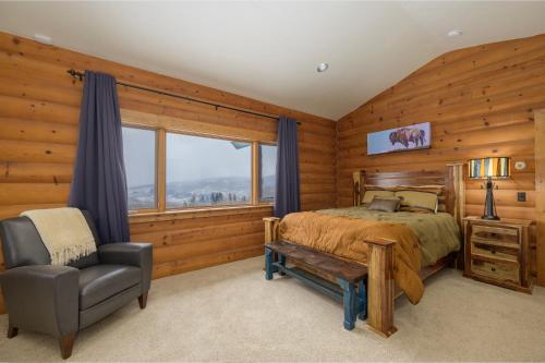 a bedroom with a bed and a chair and a window at 2665 Golden Edge Drive in Kremmling