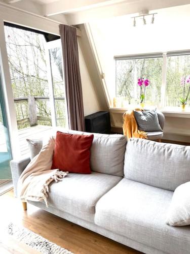 a white couch with red pillows in a living room at La petite maison Durbuy in Durbuy
