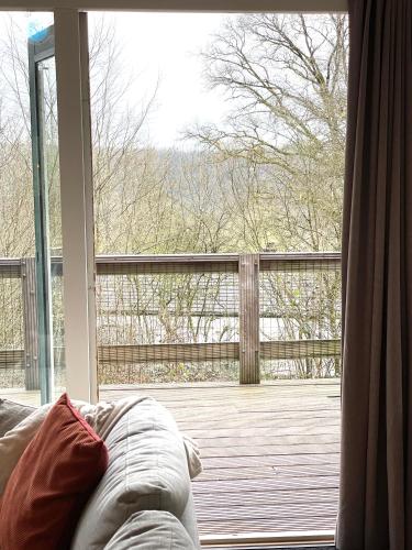 a couch sitting in front of a large window at La petite maison Durbuy in Durbuy