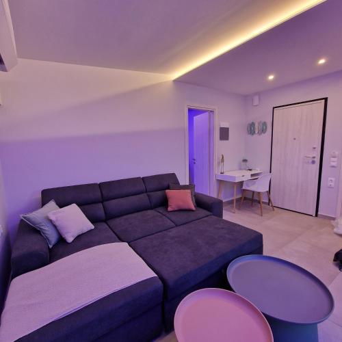 a living room with a couch and a table and chairs at Panorama Inn Hotel in Paralia Katerinis