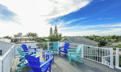 a deck with blue chairs and a blue sky at Surfer's Dream, 4 King beds, 4 trundle beds, 6 full baths, pet-friendly with a rooftop deck! in Holmes Beach