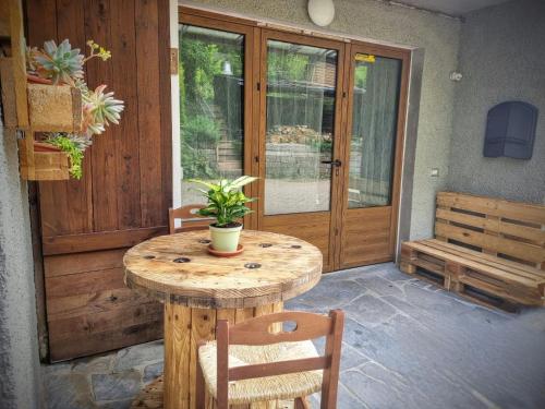 een houten tafel met een potplant op een patio bij La Casina di Sotto in Castelnuovo di Garfagnana
