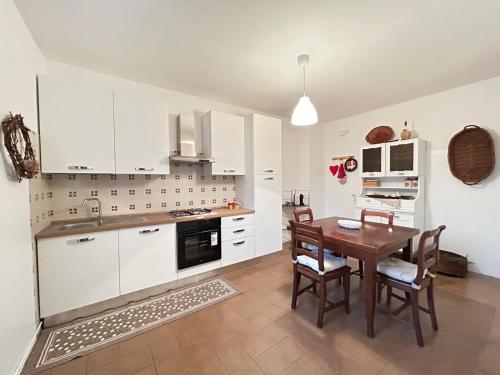 cocina con armarios blancos y mesa de madera en Casa Vacanze Nonno Giò, en Sulmona