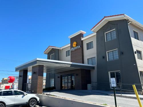 a building with a car parked in front of it at La Quinta Inn by Wyndham Albuquerque Airport in Albuquerque