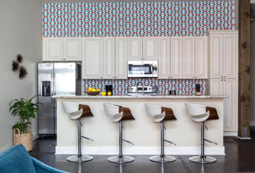 a kitchen with a counter with stools in front at The Bywater in New Orleans