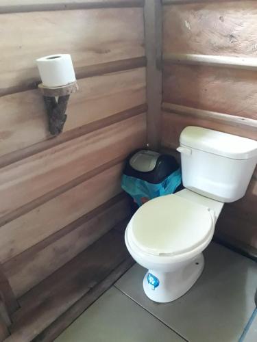 La salle de bains est pourvue de toilettes et d'un mur en bois. dans l'établissement Pacaya Samiria Camping, 