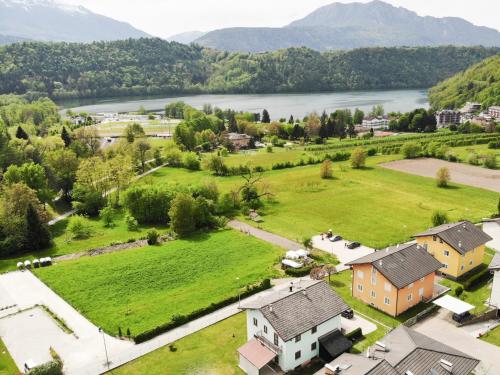 an aerial view of a village with a river and mountains at Lake View Levico in Levico Terme