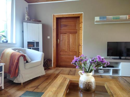 a living room with a vase of flowers on a table at Ferienwohnung Steffenshagen in Pritzwalk