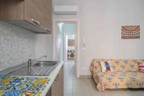 uma cozinha com um lavatório e um sofá num quarto em Casa Carlotta em Noto