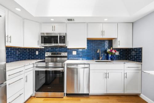 a kitchen with white cabinets and stainless steel appliances at Beach Rd, 300ft to Beach Access & 500ft to Siesta Key Village, 2bdr in Siesta Key