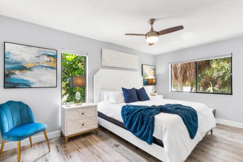 um quarto com uma cama e uma cadeira azul em Beach Road Condo, Private Deck, Siesta Key Village and Beach Walkable em Siesta Key