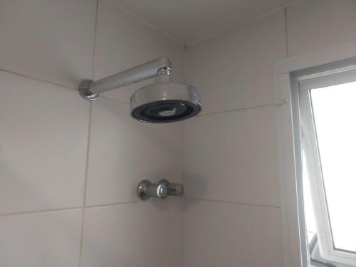 una ducha con luz y pared de azulejos en Loft no Recreio, en Río de Janeiro