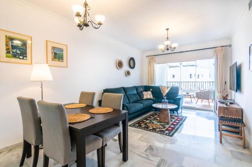 ein Wohnzimmer mit einem blauen Sofa und einem Tisch in der Unterkunft La Cala de Mijas Miraflores in Mijas