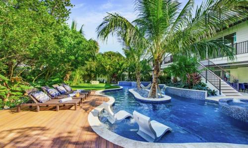 a swimming pool with lounge chairs and a palm tree at Canal Front with Dock, 9 beds, 8,5 baths on Anna Maria Island! in Anna Maria