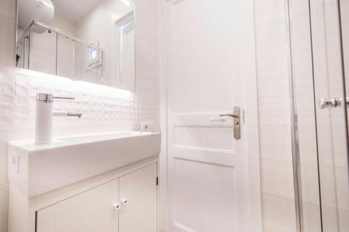 a white bathroom with a sink and a shower at Carrer de Santa Madrona, 1 in Barcelona