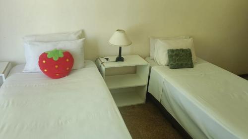 sypialnia z 2 łóżkami i poduszką truskawkową na łóżku w obiekcie Sharing is Caring w mieście Mahikeng