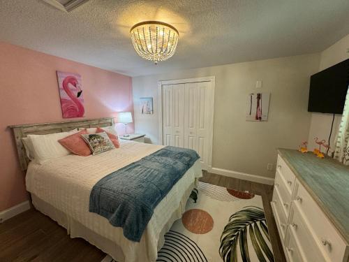 1 dormitorio con cama y lámpara de araña en Frangipani - 544F, en Sarasota