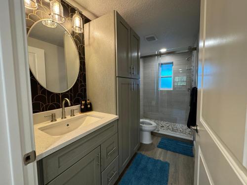 y baño con lavabo, espejo y aseo. en Frangipani - 544F, en Sarasota
