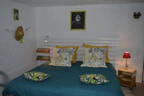 a bedroom with a bed with blue sheets and pillows at Le Montadou in Coucouron