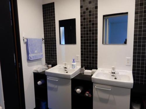 een badkamer met 2 wastafels, een toilet en een spiegel bij クレインネスト201貸切9人部屋民泊 海遊館2分、USJ25分無料駐車場 in Osaka
