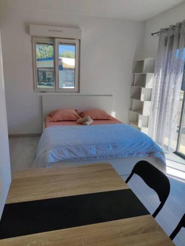 une chambre avec un grand lit et une table dans l'établissement Joli studio 3 avec piscine au calme absolu, à Cabriès