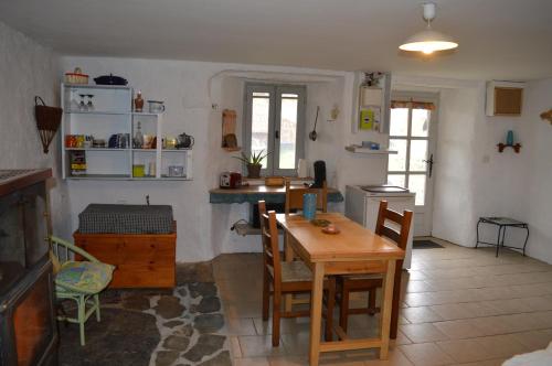 eine Küche mit einem Tisch und Stühlen im Zimmer in der Unterkunft Le Montadou in Coucouron
