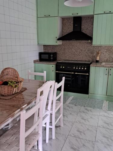 a kitchen with green cabinets and a table and chairs at HyP - Mar y Descanso in Sotomayor